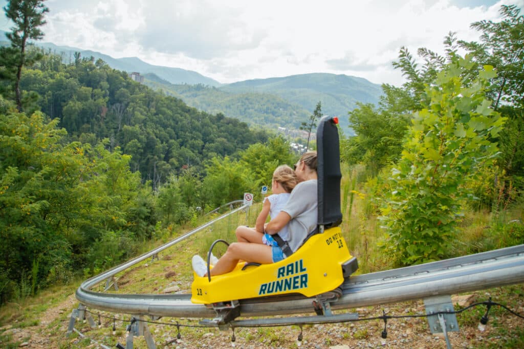 Mother and Daughter race down the Smoky Mountains at Anakeesta on the Rail Runner Mountain Coaster